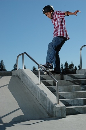 a skateboarder going down a  railing very, very, carefully